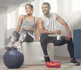 Image showing Working out together is a lot more fun than doing it alone. two young athletes sitting together at the gym.
