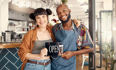 Image showing We started from the ground up. two business colleagues holding an open for business sign.