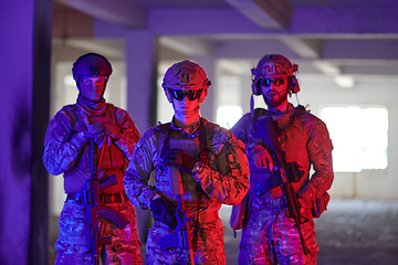 Image showing Soldier squad team walking in urban environment colored lightis