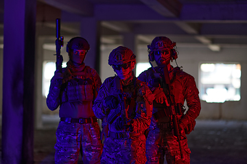 Image showing Soldier squad team walking in urban environment colored lightis