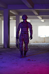 Image showing A professional soldier undertakes a perilous mission in an abandoned building illuminated by neon blue and purple lights