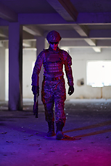 Image showing A professional soldier undertakes a perilous mission in an abandoned building illuminated by neon blue and purple lights