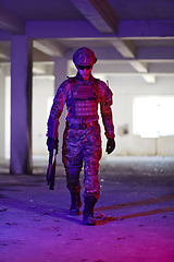 Image showing A professional soldier undertakes a perilous mission in an abandoned building illuminated by neon blue and purple lights