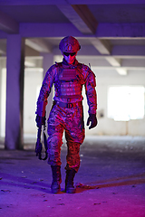 Image showing A professional soldier undertakes a perilous mission in an abandoned building illuminated by neon blue and purple lights