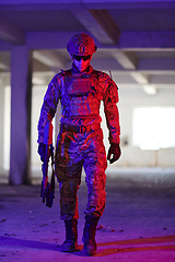 Image showing A professional soldier undertakes a perilous mission in an abandoned building illuminated by neon blue and purple lights