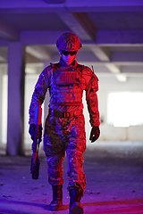 Image showing A professional soldier undertakes a perilous mission in an abandoned building illuminated by neon blue and purple lights