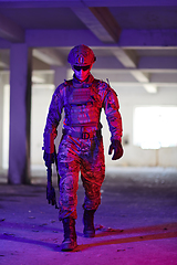 Image showing A professional soldier undertakes a perilous mission in an abandoned building illuminated by neon blue and purple lights