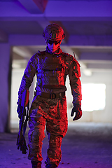 Image showing A professional soldier undertakes a perilous mission in an abandoned building illuminated by neon blue and purple lights