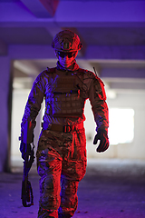 Image showing A professional soldier undertakes a perilous mission in an abandoned building illuminated by neon blue and purple lights