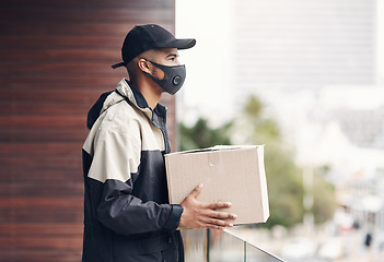 Image showing Whatever your location, hell get your delivery to you. a masked young man delivering a package to a place of residence.