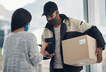 Image showing For a safer delivery keep it contact free. a masked young man and woman using smartphones during a home delivery.