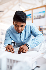 Image showing Architects think with their hands. a young architect designing a building model in a modern office.