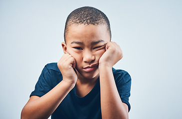 Image showing Nobody wants to play with me. Studio shot of a cute little boy looking bored against a grey background.