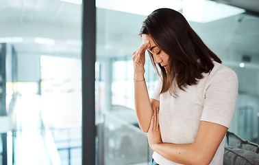 Image showing Trying to overcome the fear of losing her job. a young businesswoman looking stressed out in an office.