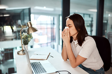 Image showing Her sinuses are kicking in. a young businesswoman blowing her nose while working in an office.