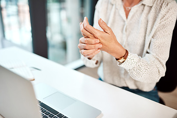 Image showing Trying to loosen the stiffness in her hands. Closeup shot of an unrecognisable businesswoman experiencing discomfort in her hand while working in an office.