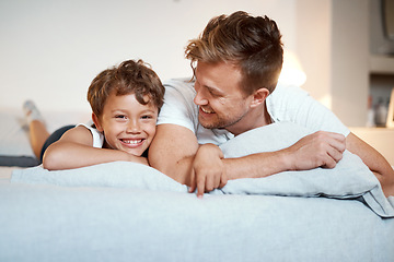 Image showing Were ready for some pillow time. a man and his son lying on a bed together.