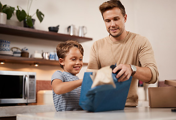 Image showing I cant wait to see whats inside. a boy opening a gift from his father at home.