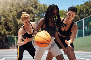 Image showing Dribbling the ball down the court. a group of sporty young women playing basketball on a sports court.