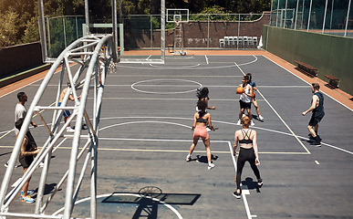 Image showing The pros are at play. a group of sporty young people playing basketball on a sports court.