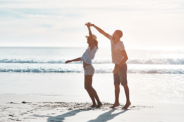 Image showing True love stories never have endings. a young couple dancing together at the beach.