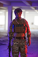 Image showing A professional soldier undertakes a perilous mission in an abandoned building illuminated by neon blue and purple lights