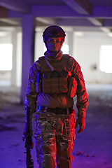 Image showing A professional soldier undertakes a perilous mission in an abandoned building illuminated by neon blue and purple lights
