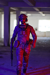 Image showing A professional soldier undertakes a perilous mission in an abandoned building illuminated by neon blue and purple lights