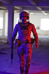 Image showing A professional soldier undertakes a perilous mission in an abandoned building illuminated by neon blue and purple lights