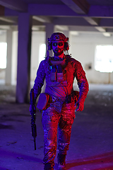 Image showing A professional soldier undertakes a perilous mission in an abandoned building illuminated by neon blue and purple lights