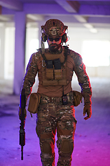 Image showing A professional soldier undertakes a perilous mission in an abandoned building illuminated by neon blue and purple lights