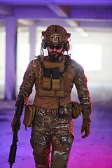 Image showing A professional soldier undertakes a perilous mission in an abandoned building illuminated by neon blue and purple lights