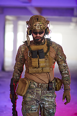 Image showing A professional soldier undertakes a perilous mission in an abandoned building illuminated by neon blue and purple lights