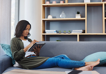 Image showing What more could you want from a weekend. an attractive young woman using a digital tablet on the sofa at home.