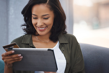 Image showing Shes been given the gift of convenience. an attractive young woman using a digital tablet and credit card on the sofa at home.