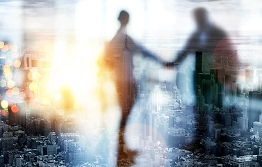 Image showing Together we can achieve so much more. Defocused shot of two businesspeople shaking hands in an office.