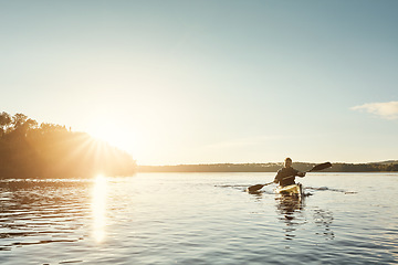 Image showing Life is good on the water. a young man kayaking on a lake outdoors.