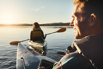 Image showing Watching her back while we kayak. a young couple kayaking on a lake outdoors.