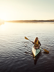 Image showing She finds peace being alone on the water. a beautiful young woman kayaking on a lake outdoors.