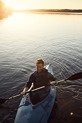 Image showing Happy to be kayaking. High angle shot of a young man kayaking on a lake outdoors.