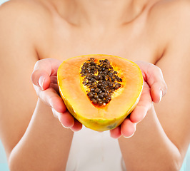 Image showing Papaya. Studio shot of an unrecognizable young woman posing with a papaya against a light background.