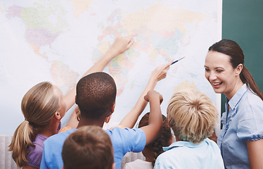 Image showing Geography can be fun. A group of children looking at a world map during geography class.