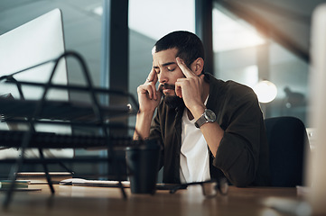 Image showing Why did I agree to work these hours. a young businessman feeling stressed while working late at night in a modern office.