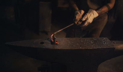 Image showing Even the strongest steel can sometimes bend. a blacksmith working with a hot metal rod in a foundry.