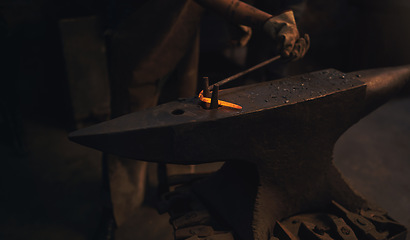 Image showing Whats bent can be just as beautiful. a blacksmith working with a hot metal rod in a foundry.