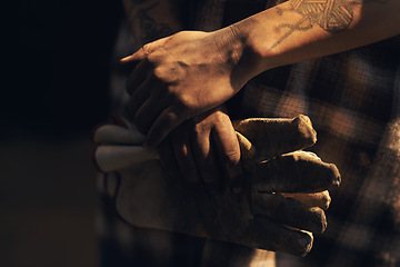 Image showing Hardworking hands hold a lot of pride. an unrecognisable holding a pair of gloves while working at a foundry.