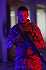 Image showing A professional soldier undertakes a perilous mission in an abandoned building illuminated by neon blue and purple lights