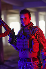 Image showing A professional soldier undertakes a perilous mission in an abandoned building illuminated by neon blue and purple lights