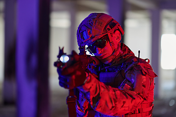 Image showing A professional soldier undertakes a perilous mission in an abandoned building illuminated by neon blue and purple lights