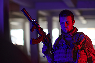 Image showing A professional soldier undertakes a perilous mission in an abandoned building illuminated by neon blue and purple lights